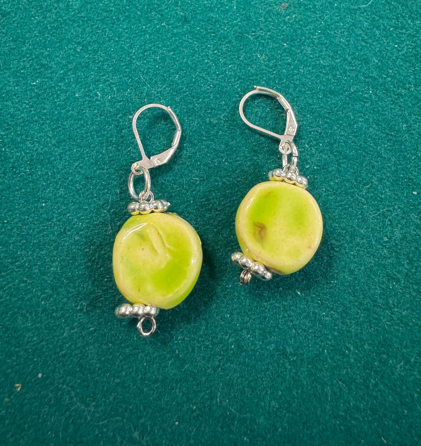 One-of-a-kind hand built ceramic circle shaped earrings that are hand glazed soft green by Las Vegas artist JanDWolf. Art you can wear that no one else has. Be original. Be unique. Be you. 
 Soft Green Circle Earrings